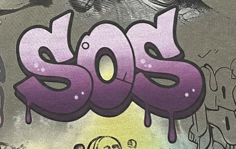 Close-up of purple gradient lettering and coloured graphics on a garment sample panel