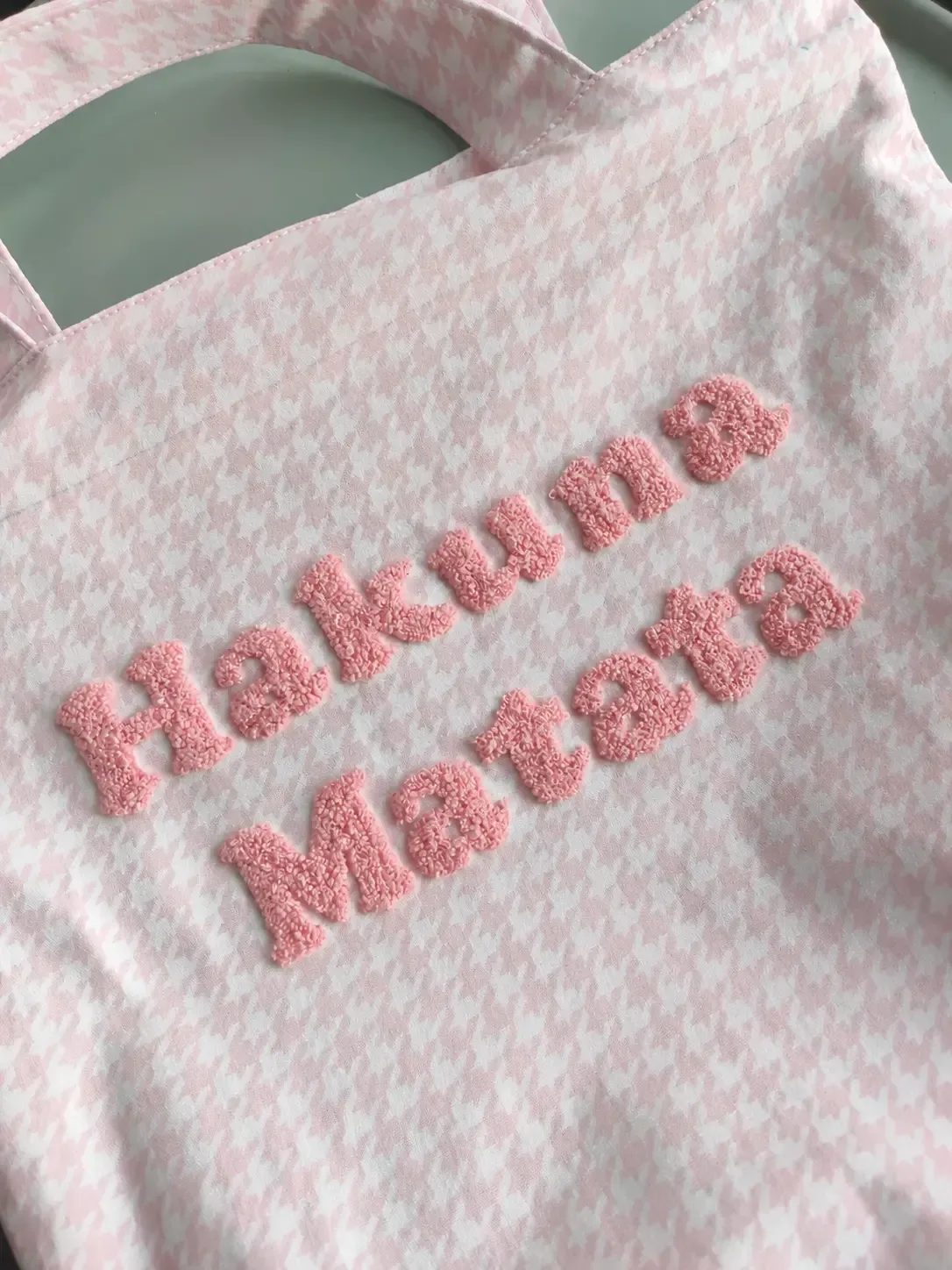 Pink piled chenille lettering on a pink and white patterned garment reference