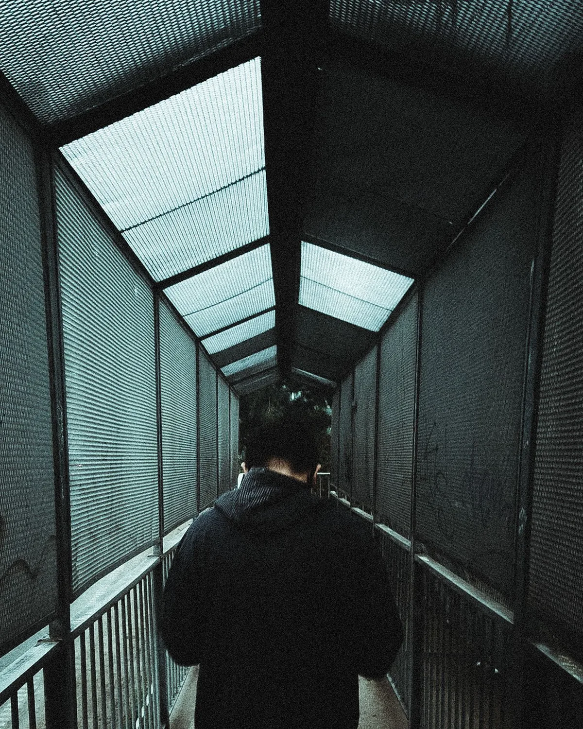 Model in heavyweight streetwear walking through an urban walkway