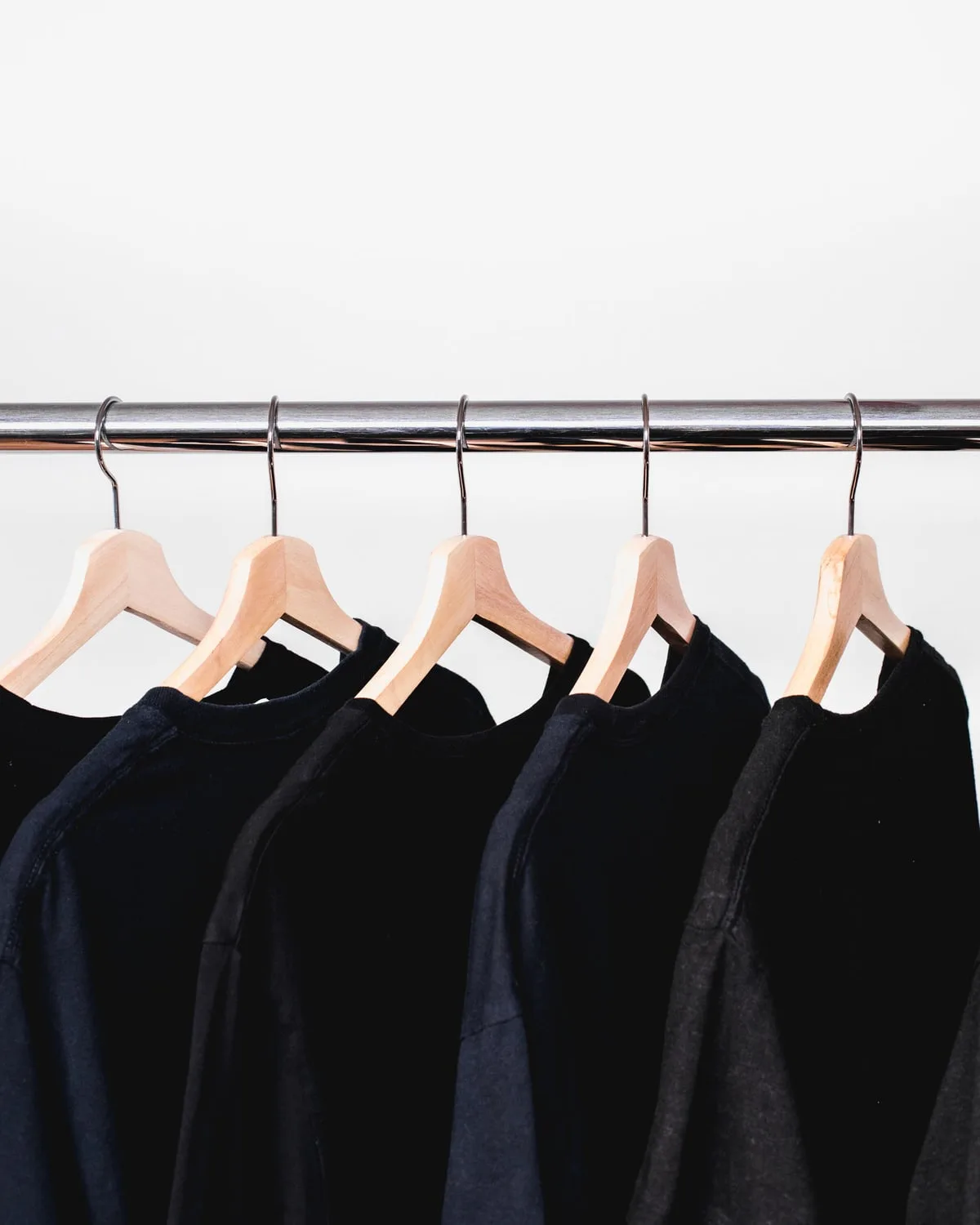 Representative lifestyle image — Styled reference — black crewnecks on the rail