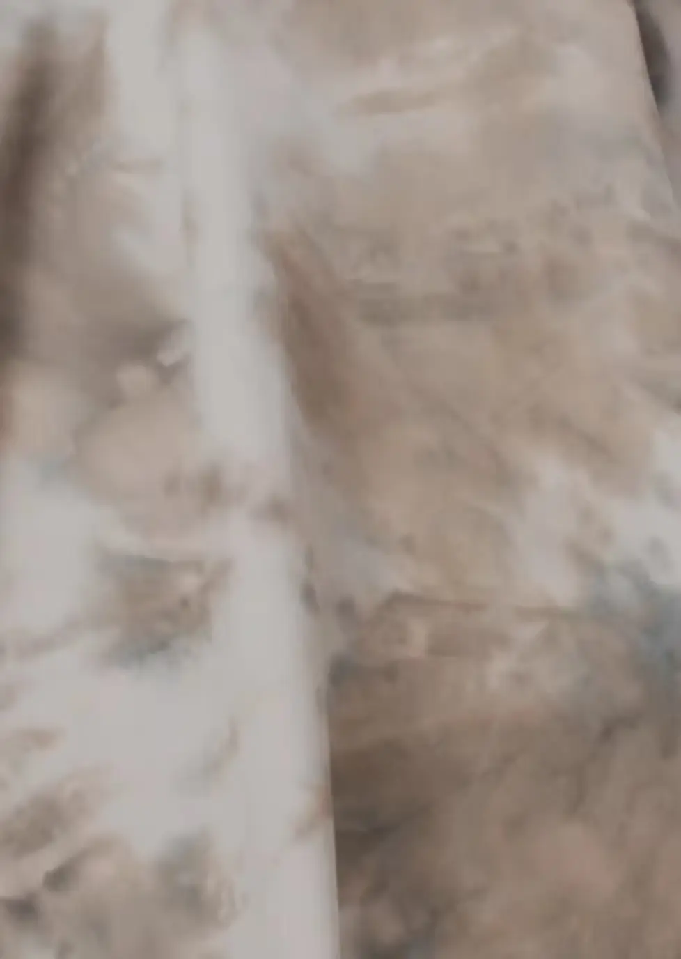 Beige and white fabric with irregular pale resist-dye areas